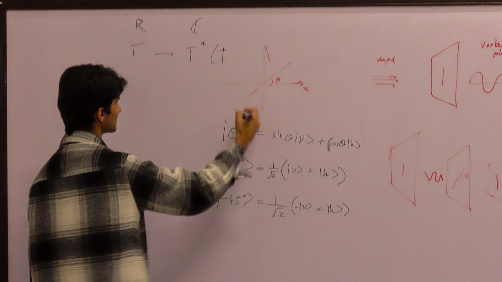 A speaker deriving a quantum circuit identity on a whiteboard during Day 1.