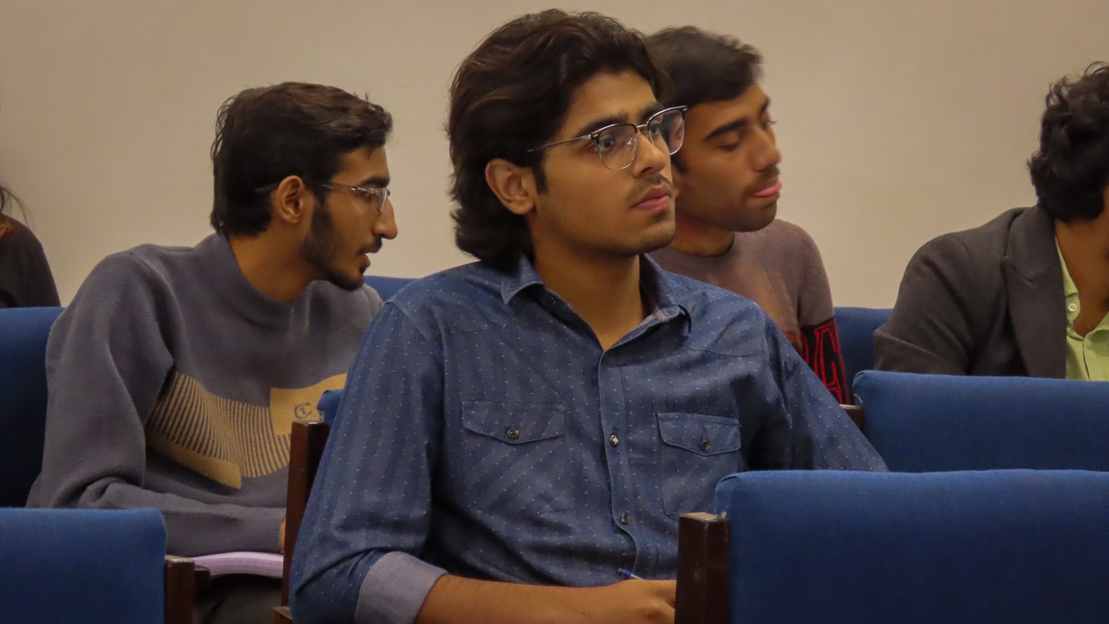 Students following the opening lecture from the front rows.